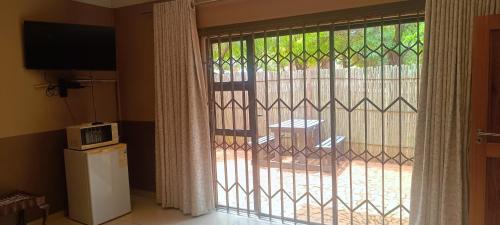 a door with a window with a microwave next to it at Kareespruit Game Ranch & Guest House in Zeerust
