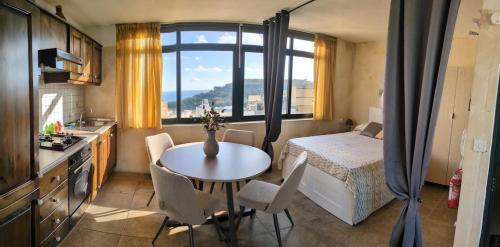 a bedroom with a table and a bed and a kitchen at Harruba Flt 3 Triq il Gudja in Mġarr