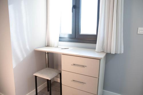 a desk with a chair next to a window at Hostal Rosario Galindo in Cúllar-Vega