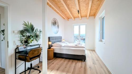 a bedroom with a bed and a desk and a window at ANDRISS - Stilvolle Lofts & Penthouses - Premium Wohnen mit Parkplatz & Workstations in Kaiserslautern