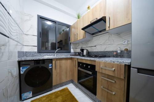a kitchen with a sink and a dishwasher at Nice & Comfortable 2BHK panoramic balcony with swimming pool in Aïn Harrouda