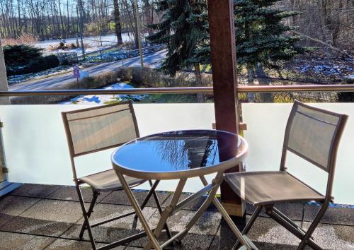 two chairs and a table on a balcony with a view at Am Trebeteich in Pulsnitz
