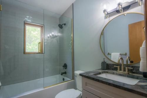 a bathroom with a tub and a sink and a mirror at Mountain View 3BR with Sunroom, Close to Ski and Trails in Maggie Valley