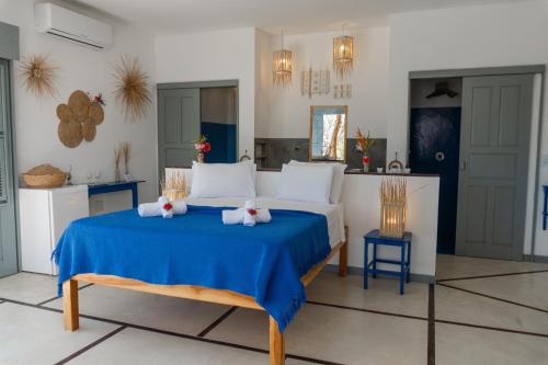 a bedroom with a blue bed with two towels at Pousada Recanto Beija-Flor in Fortim