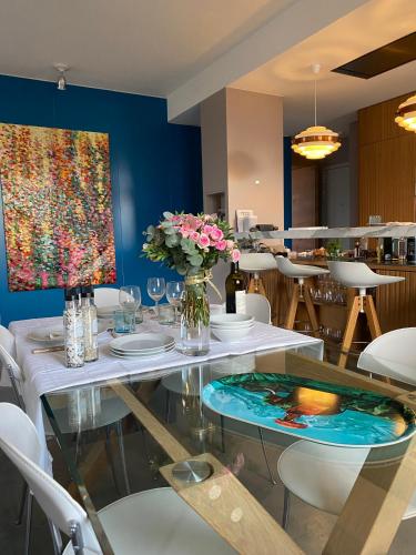 une salle à manger avec une table en verre et des fleurs. dans l'établissement Click! Magical Views Notre-Dame, Vieux Port & Rooftops - Walk to All, à Marseille