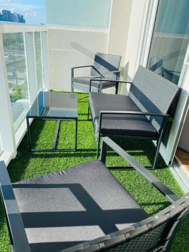 two chairs and a table on a balcony at Departamento sobre la Playa con vista a la Collins Ave in Sunny Isles Beach