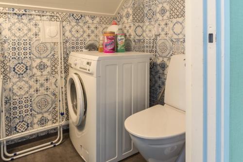 a bathroom with a washing machine and a toilet at Photoeverhome in Bengtsfors
