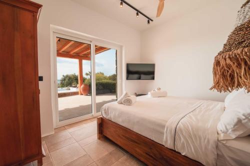 a bedroom with a bed and a large window at Villa Zina Sunset View St Lazaros 7 plus 1 Bedroom in Psarou