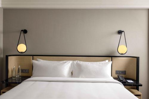 a large bed with two lights above it at Pullman Chennai Anna Salai - Premium Brand By Accor in Chennai