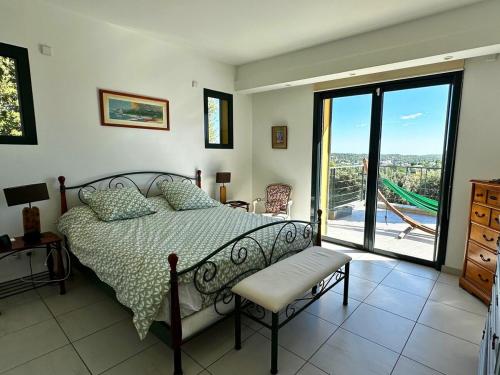 une chambre avec un lit et une grande fenêtre dans l'établissement Villa d'exception avec Piscine et Jardin, à Saint-Gély-du-Fesc