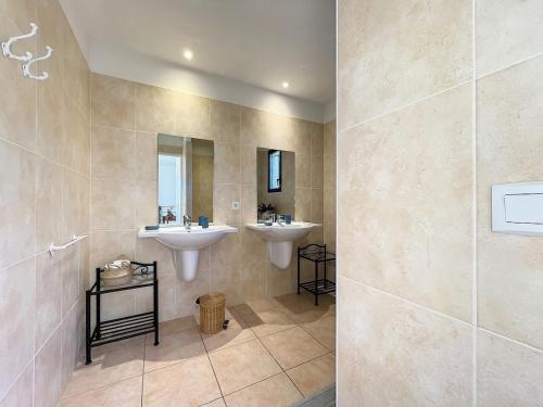 une salle de bain avec deux lavabos et un miroir dans l'établissement Villa d'exception avec Piscine et Jardin, à Saint-Gély-du-Fesc
