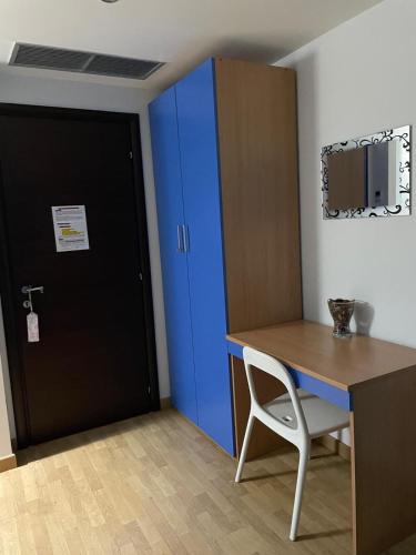 an office with a blue cabinet and a desk and a chair at Stanza Platone in Corigliano Calabro