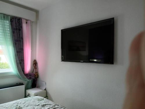 une chambre avec une télévision à écran plat au mur dans l'établissement Location chambre 2 personnes chez Angela, à Cannes
