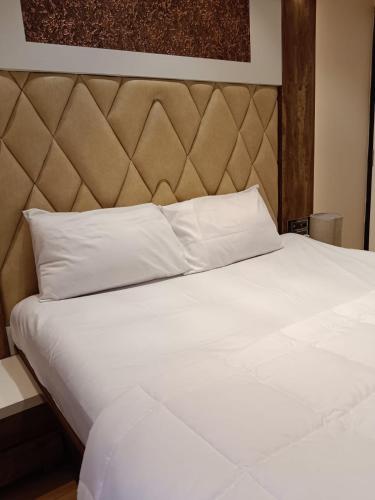 a large white bed with a large headboard at Satya Stays Premium Boutique Apartment in Navi Mumbai