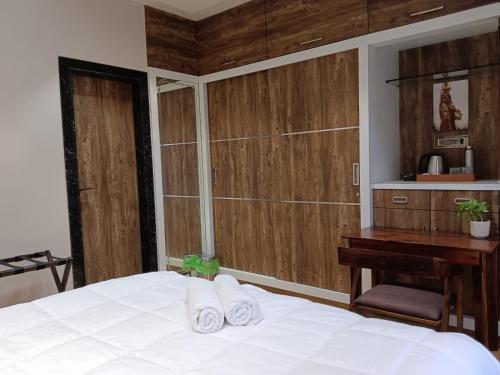 a bedroom with a white bed and a wooden wall at Satya Stays Premium Boutique Apartment in Navi Mumbai