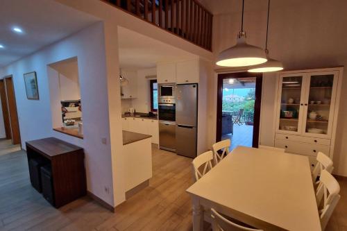 Una cocina y un comedor con mesa y sillas. en The North House by Ponta Negra Azores, en Biscoitos