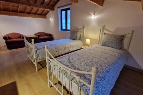 1 dormitorio con 2 camas individuales y 1 silla en The North House by Ponta Negra Azores, en Biscoitos