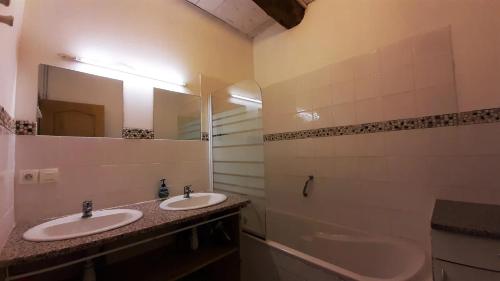 une salle de bain avec deux lavabos, une baignoire et un miroir dans l'établissement Cabana & Les Gîtes de Michon, à Mazet-Saint-Voy