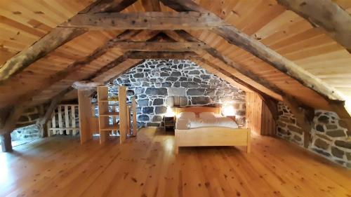 Cette chambre mansardée dispose d'une cheminée en pierre. dans l'établissement Cabana & Les Gîtes de Michon, à Mazet-Saint-Voy