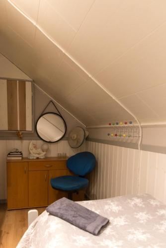 a room with a bed and two blue chairs at Photoeverhome in Bengtsfors