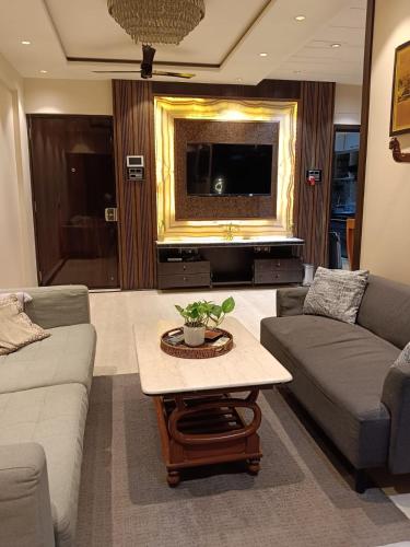 a living room with a couch and a table at Satya Stays Premium Boutique Apartment in Navi Mumbai