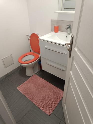 une salle de bain avec des toilettes rouges et un lavabo dans l'établissement Beau 2 pieces Vieux port de Marseille, à Marseille