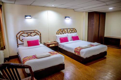 攀牙Lukmuang 2 Hotel的两张位于酒店客房的床,配有粉红色枕头
