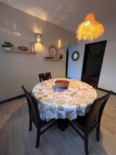 a dining room with a table with chairs and a chandelier at Appartement Lili in Grand-Baie