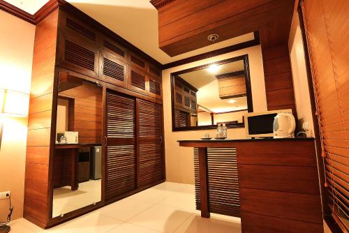 a kitchen with wood paneling and a desk with a computer at Citystate Asturias Hotel Palawan in Puerto Princesa City