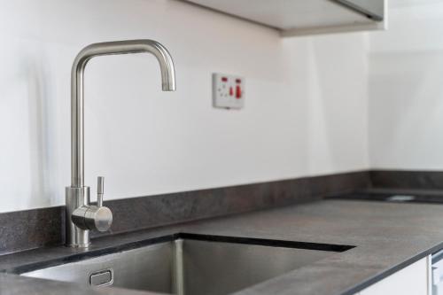 a stainless steel sink in a kitchen with a counter at Cosy, Studio in Dudley with Netflix and Parking in Dudley