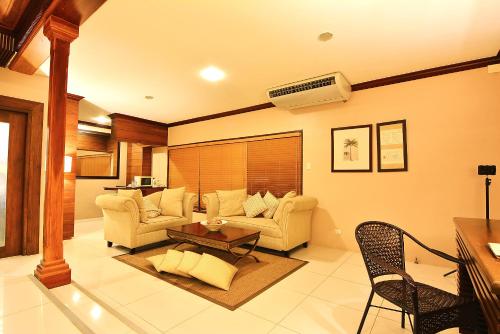 a living room with a couch and a table at Citystate Asturias Hotel Palawan in Puerto Princesa City