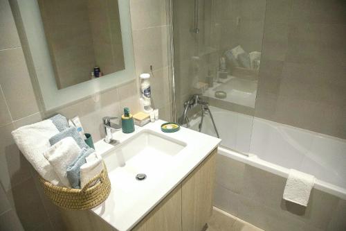 a bathroom with a white sink and a shower at Apartment BW Maria Belgrade in Sajmište