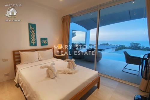 a bedroom with a bed with two stuffed animals on it at Villa Azula - Stunning Seaview in Ban Bang Po