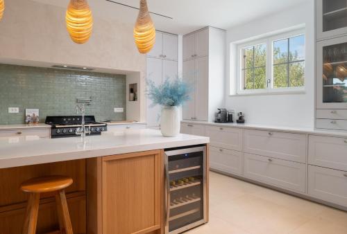 a kitchen with white cabinets and a island with a stool at Luxury Villa Marca heated pool 36m2 in Nin