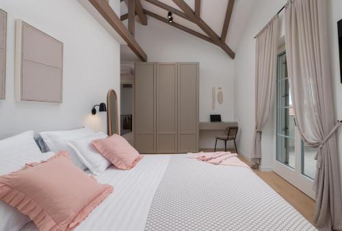 a bedroom with a large white bed with pink pillows at Luxury Villa Marca heated pool 36m2 in Nin