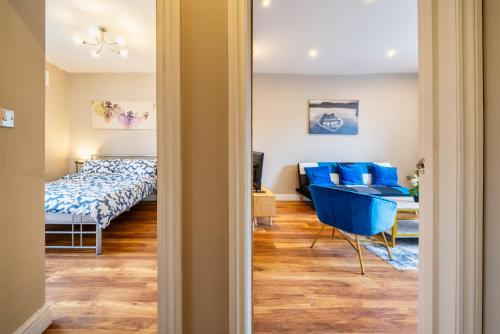a room with a bed and a blue chair at Stylish 1BR Prime Location Near Station and Shops in South Norwood