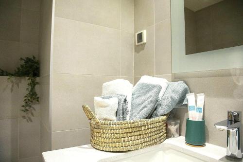 a basket of towels sitting on a sink in a bathroom at Apartment BW Maria Belgrade in Sajmište