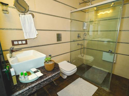a bathroom with a sink and a toilet and a shower at Plutus Luxury Boutique Stays in Mussoorie
