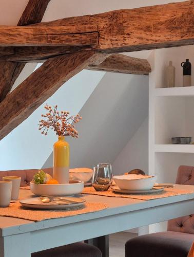 a dining table with bowls and glasses on it at L'Arbre Voyageur in Autun