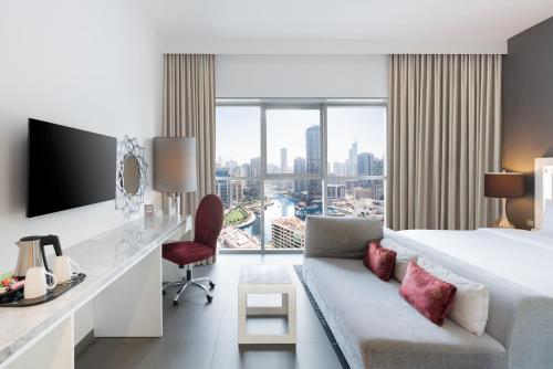 a hotel room with a king sized bed and a desk at The First Collection Dubai Marina in Dubai
