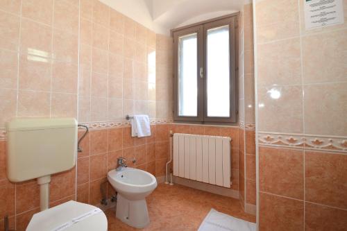 a bathroom with a toilet and a window at Boutique Hotel Kaštel in Motovun