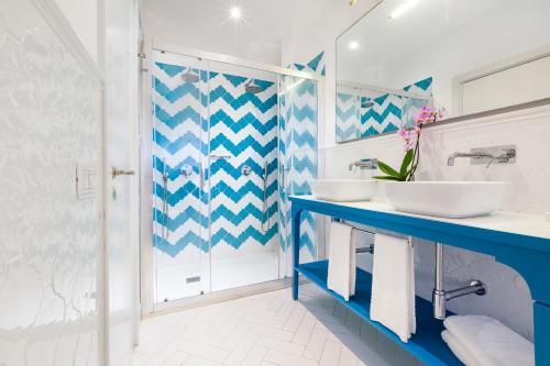 a blue and white bathroom with two sinks and a shower at Alimuri Bay Resort in Meta