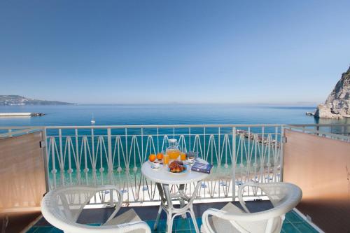 a table and chairs on a balcony with the ocean at Alimuri Bay Resort in Meta