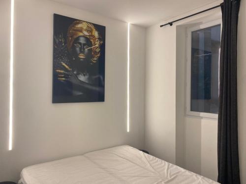 une chambre avec un lit et un tableau au mur dans l'établissement Cannes 2 pièces Contemporain, à Cannes