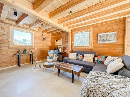 una sala de estar con un sofá y una mesa en Chalet neuf le doux glace, en Valloire