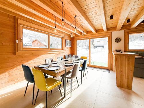 une salle à manger avec une longue table et des chaises dans l'établissement Chalet neuf le doux glace, à Valloire