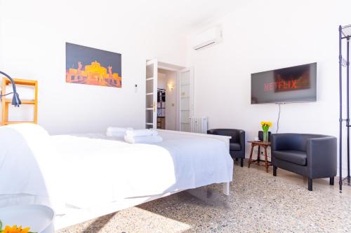 ein weißes Schlafzimmer mit 2 Betten und 2 Stühlen in der Unterkunft Elegantis La Dolce Vista Apartment with private terrace and fantastic View in Rom