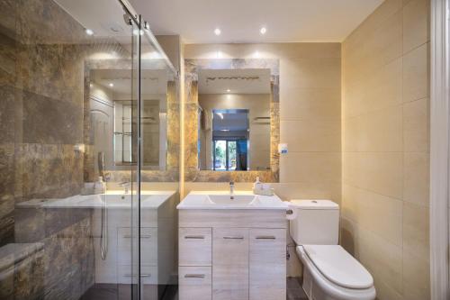 ein Badezimmer mit Toilette, Waschbecken und Dusche in der Unterkunft VillaCINCO in Sitio de Calahonda