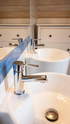 a bathroom with two sinks and a chrome faucet at Sasek Mały # Pensjonat # Jazdy Konne in Szczytno