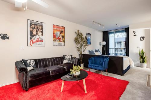 a living room with a black leather couch and a red rug at Style, Peace, Comfort in N Hollywood Next to Burbank Free Indoor Parking and Wifi in Burbank